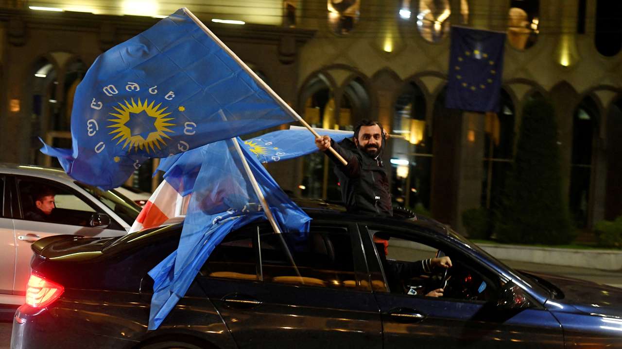Supporters of the Georgian Dream party celebrate after the announcement of exit poll results in Tbilisi