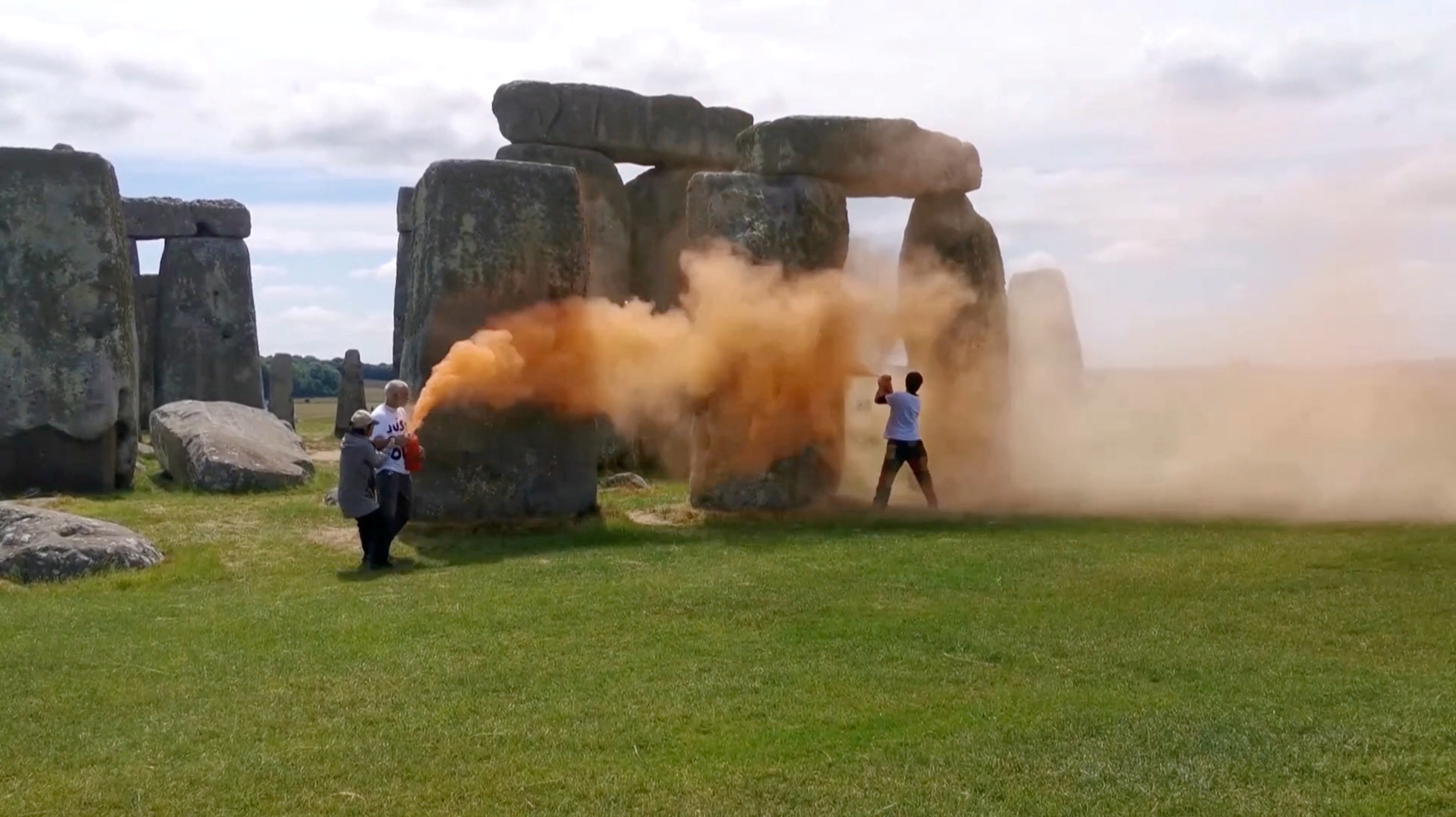 Environmental protesters spray Stonehenge with orange powder paint, in Wiltshire