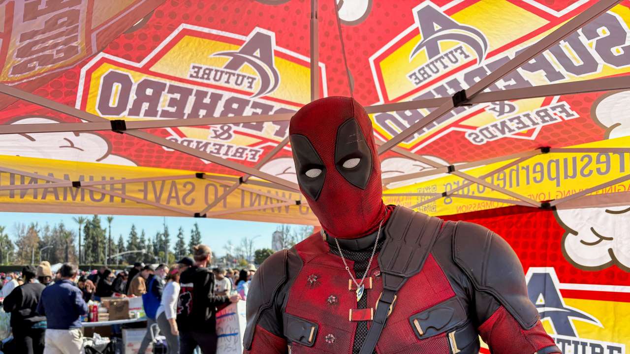 Yuri Williams, dressed as the superhero Deadpool, poses for a photo at a donation site for families displaced by the Los Angeles wildfires, in Arcadia