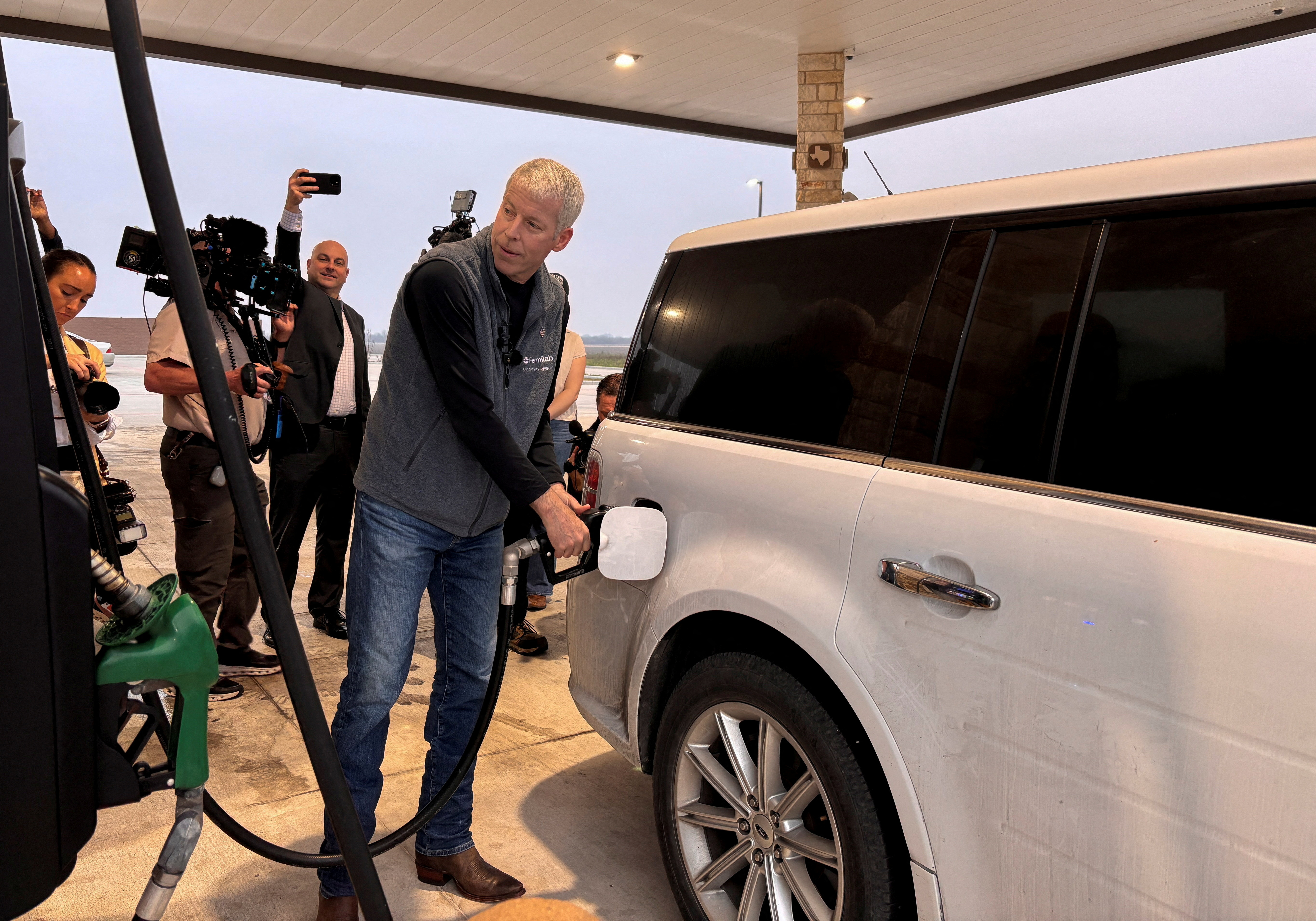 FILE PHOTO: U.S. Energy Secretary Chris Wright pumps gas and speaks with customers at a gas station in Corpus Christi, Texas