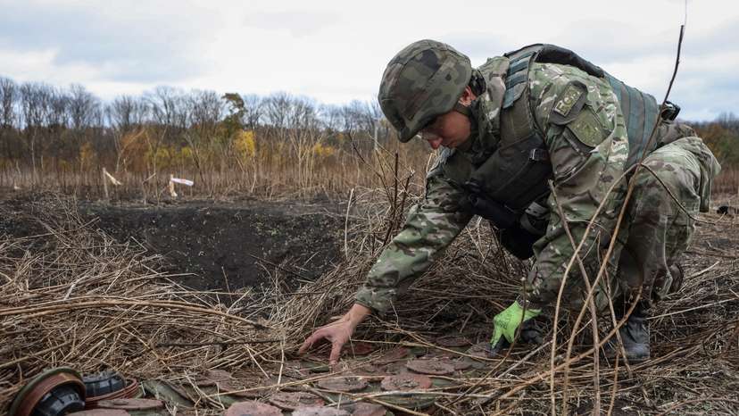 A member of the National police special demining unit works with mine fuses during a demining operation near Izum