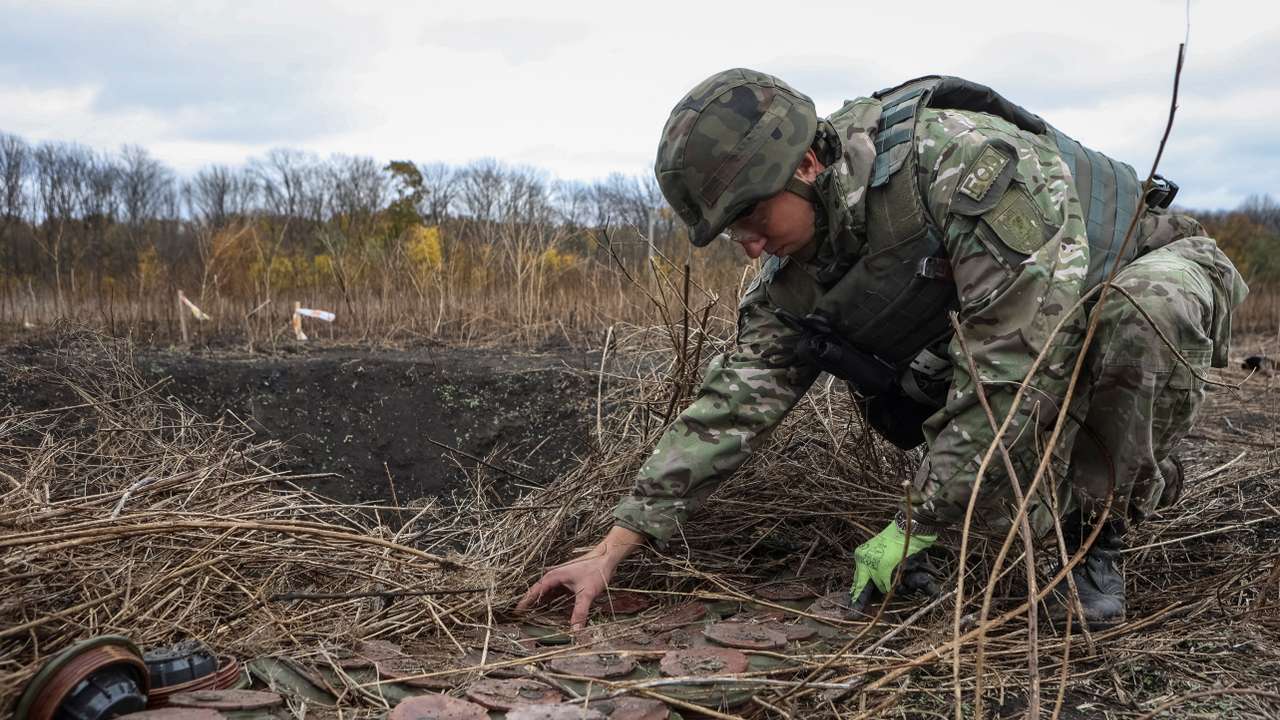 A member of the National police special demining unit works with mine fuses during a demining operation near Izum