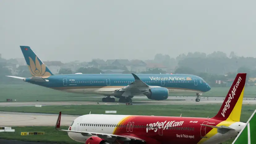 FILE PHOTO: An airplane of VietJet airline and Vietnam Airlines airplane taxi at Noi Bai International Airport in Hanoi
