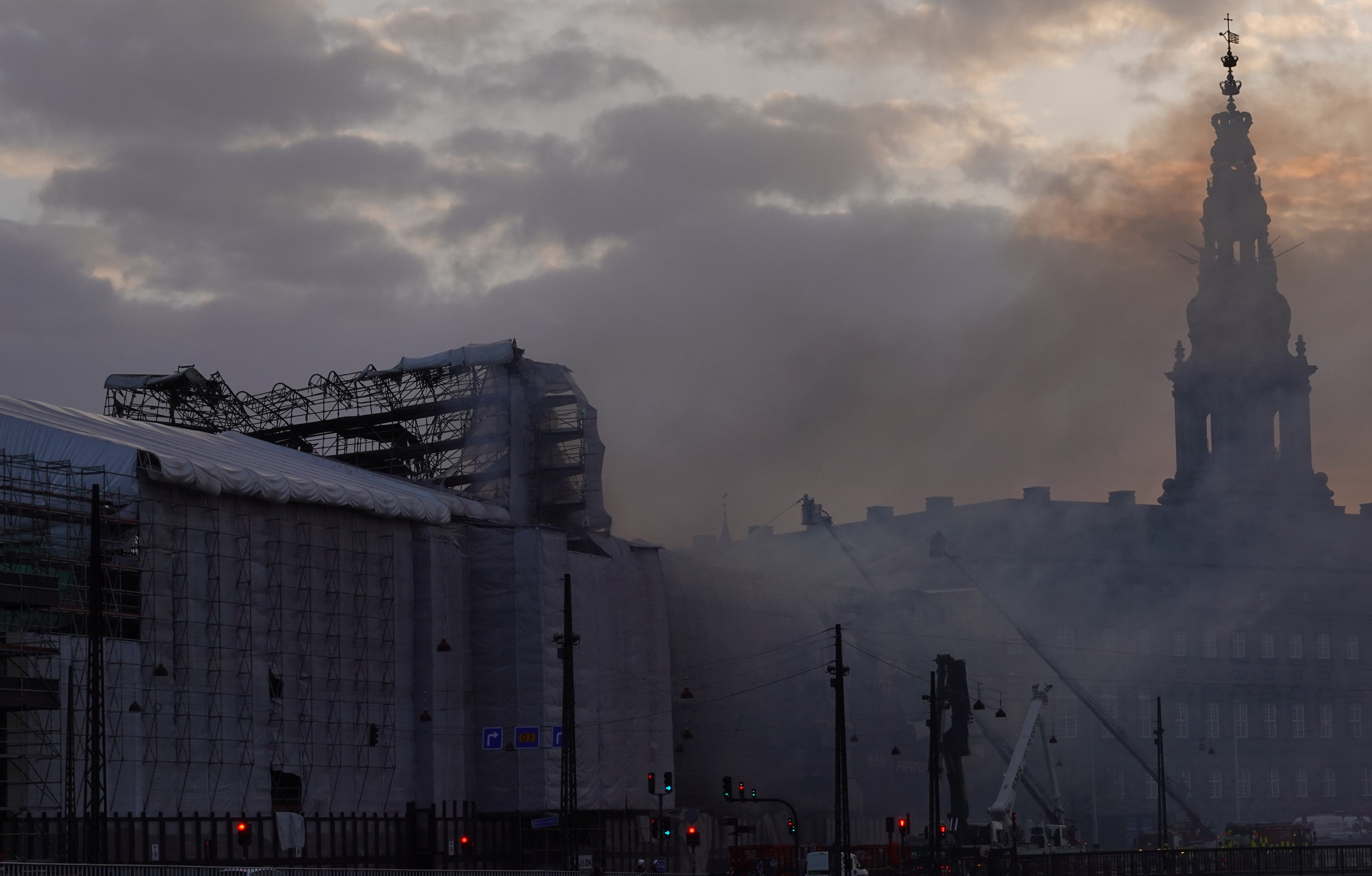 Smoke rises from Copenhagen's historic Stock Exchange as sun sets