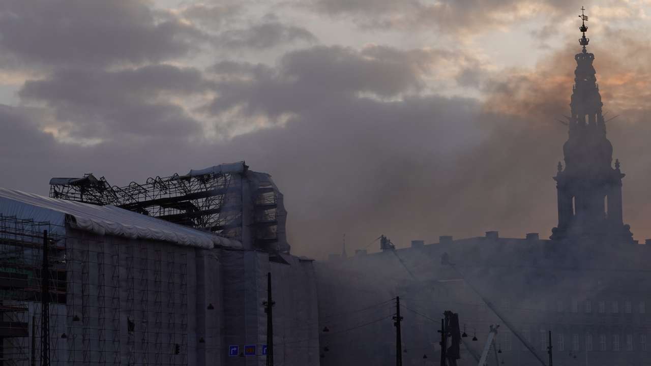 Smoke rises from Copenhagen's historic Stock Exchange as sun sets