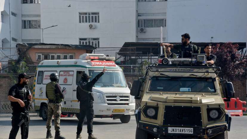 Indian security forces personnel escort an ambulance carrying the bodies of tourists who were killed in a suspected militant attack near Pahalgam, outside the police control room in Srinagar