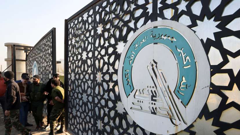 Members of an Iraqi Shi'ite armed group stand guard after an attack by a drone strike on an Iran-backed militia headquarters in Baghdad