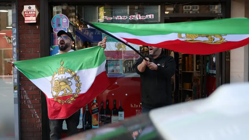 Iranian men shout and hold pre-Iranian Revolution "Lion and Sun" flags in Finchley, London