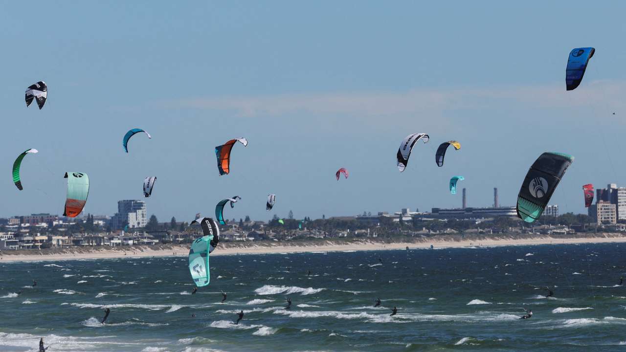 People kitesurf in Bloubergstrand beach in Cape Town