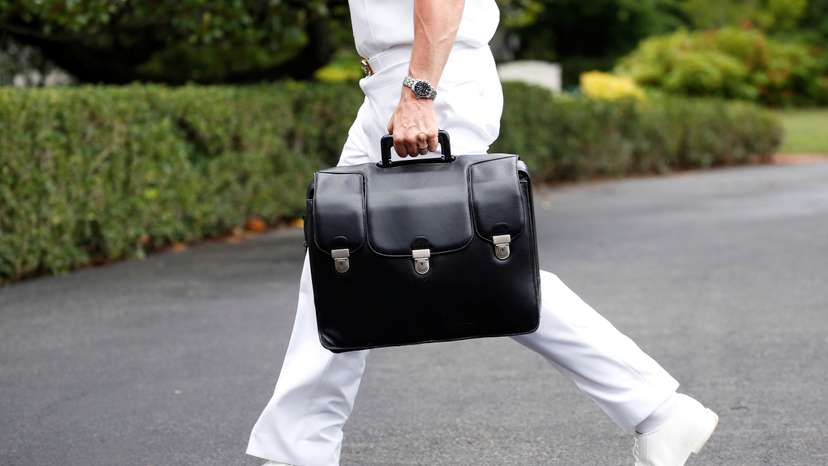 A military aide carries a briefcase containing launch codes for nuclear weapons as U.S. President Donald Trump returns to the White House in Washington