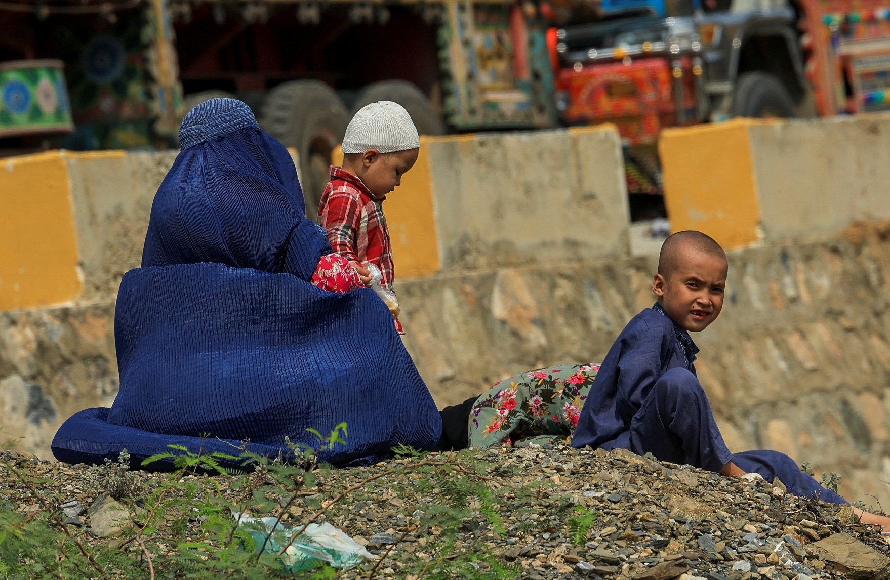 An Afghan family rests, as they head back to Afghanistan after Pakistan started to deport documented Afghan refugees, near Torkham border crossing