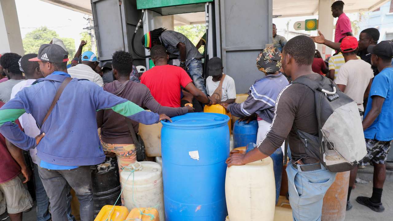 People gather to buy gasoline at a petrol station in Port-au-Prince