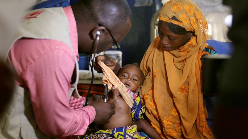 FILE PHOTO: A doctor examines a malnourished baby at the Save the Children stabilisation ward in Maiduguri, Nigeria