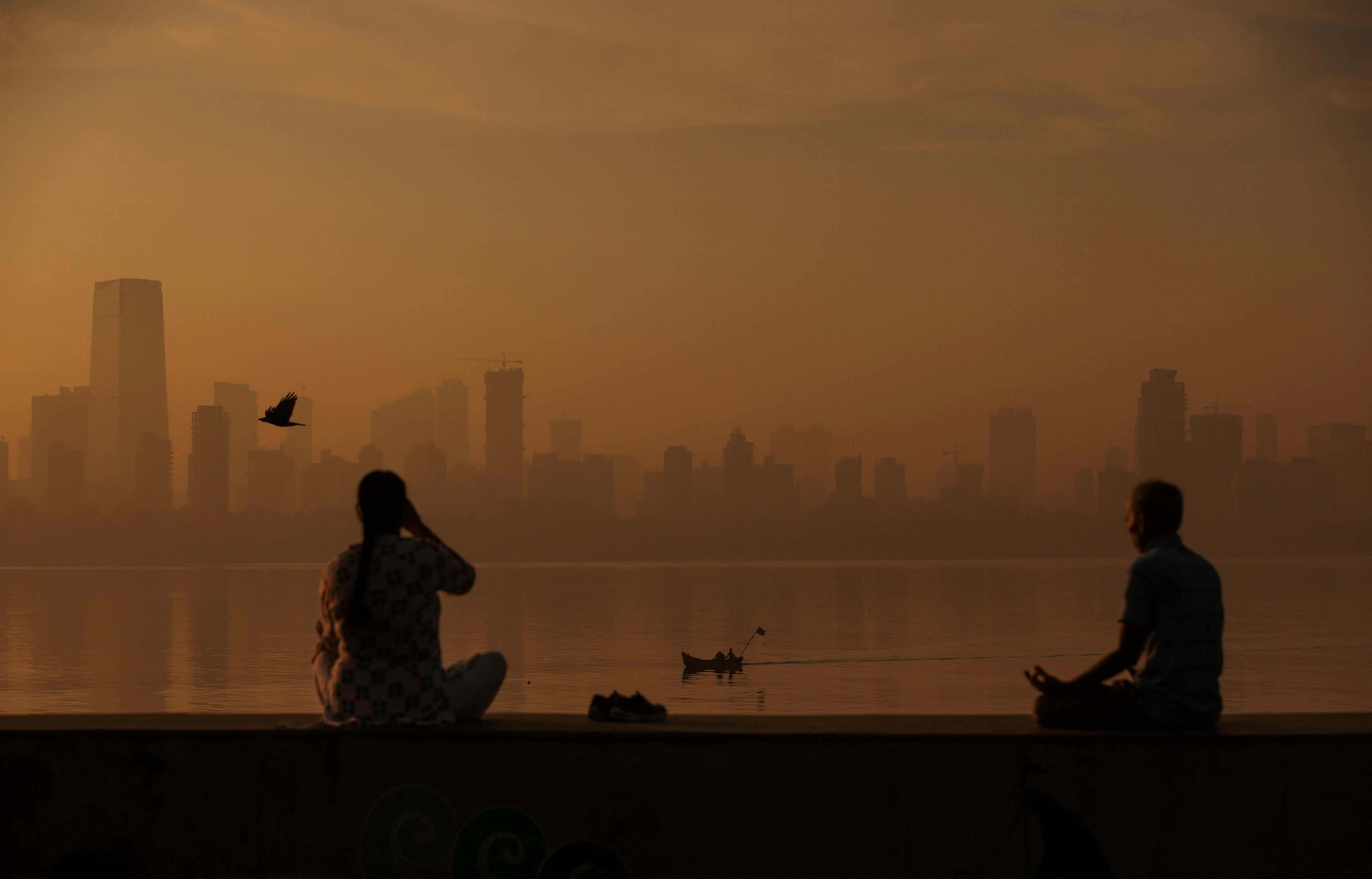 FILE PHOTO: People exercise at a promenade on a smoggy morning in Mumbai
