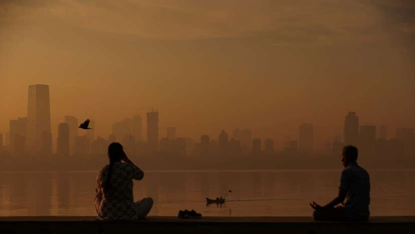 FILE PHOTO: People exercise at a promenade on a smoggy morning in Mumbai
