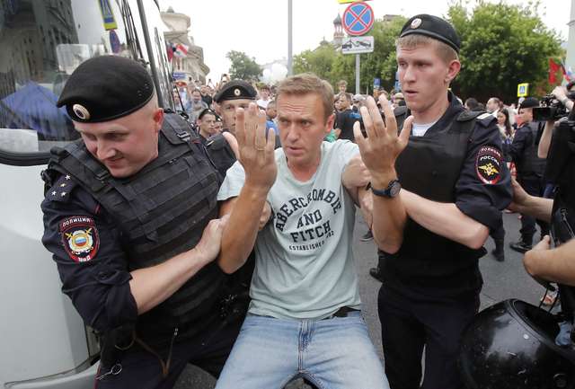 FILE PHOTO: Policemen detain Russian opposition leader Navalny during a rally in support of investigative journalist Golunov in Moscow