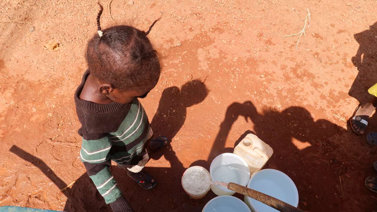 A child waits for her turn to get water in Khartoum Bahri