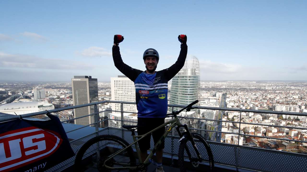 French athlete climbs 33-story tower on his mountain bike in La Defense near Paris