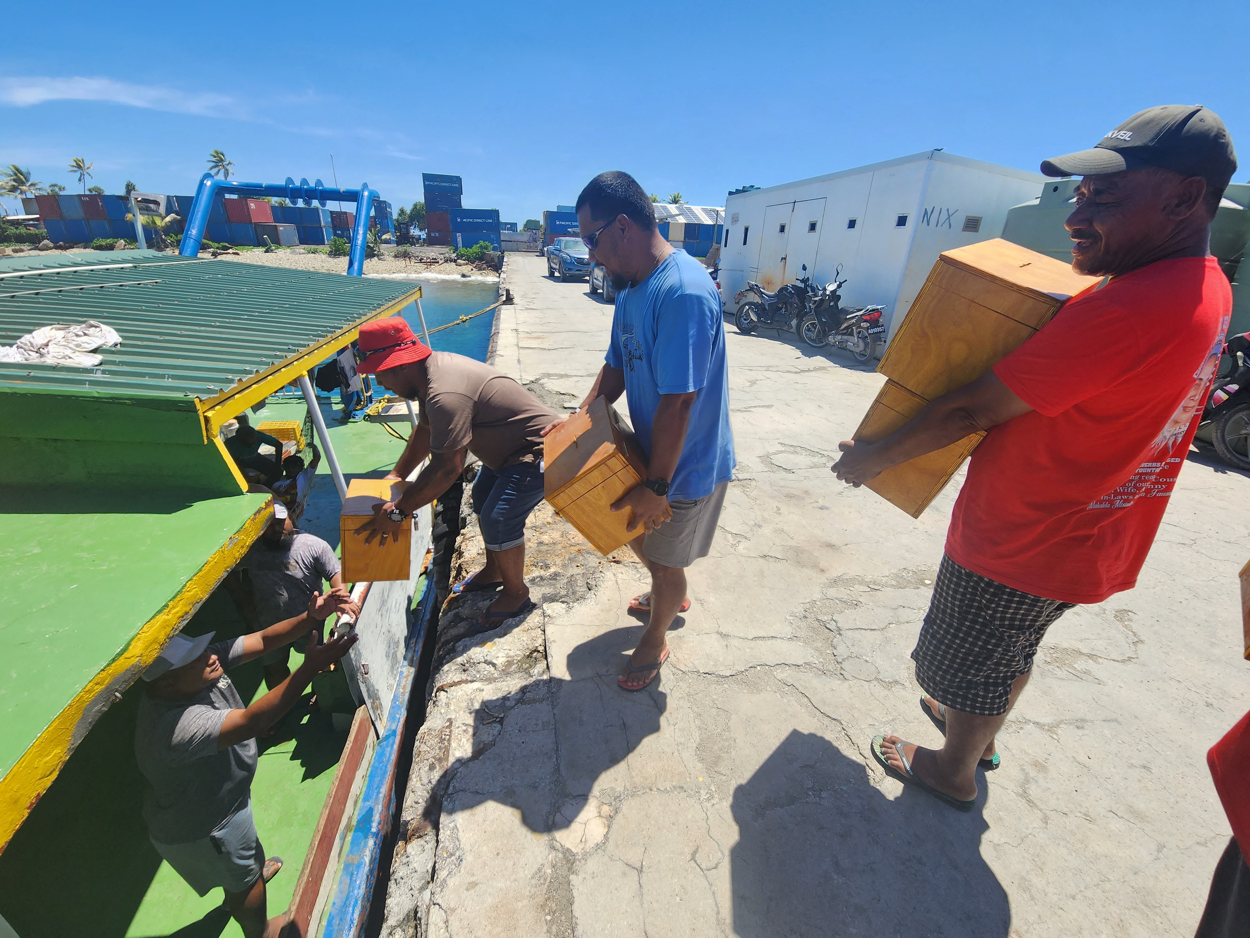 Men carry ballot boxes in preparation for the general elections on Friday, in Funafuti