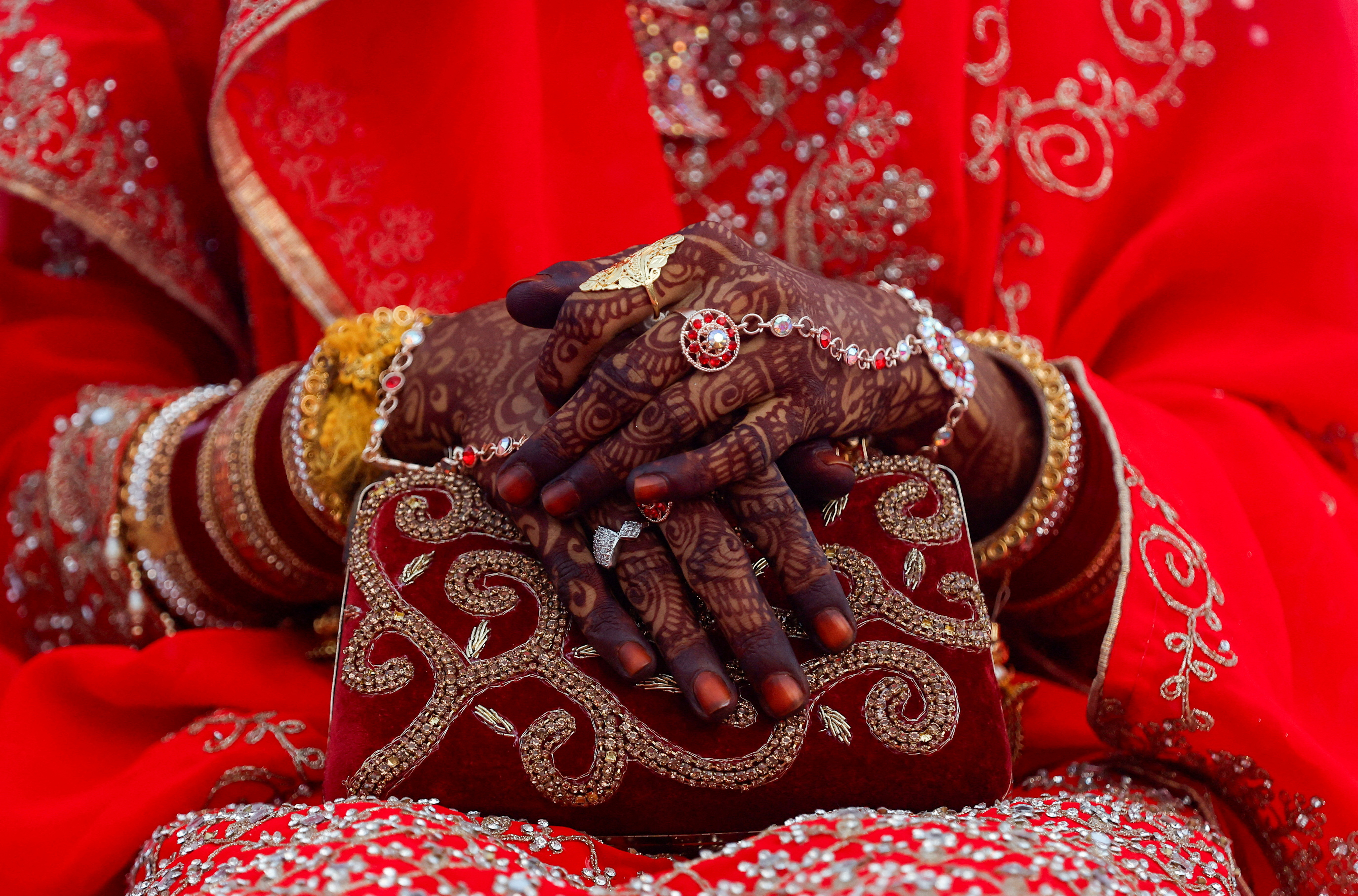 FILE PHOTO: Jewellery is seen on a bride's hand as she holds a purse during a mass marriage ceremony, in which, 51 Muslim couples took their wedding vows, in Mumbai,