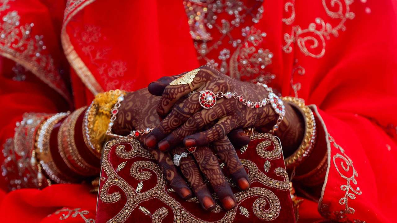 FILE PHOTO: Jewellery is seen on a bride's hand as she holds a purse during a mass marriage ceremony, in which, 51 Muslim couples took their wedding vows, in Mumbai,