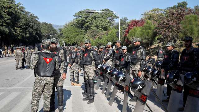 Pakistani Rangers in riot gear stand guard to prevent an anti-government rally, in Islamabad