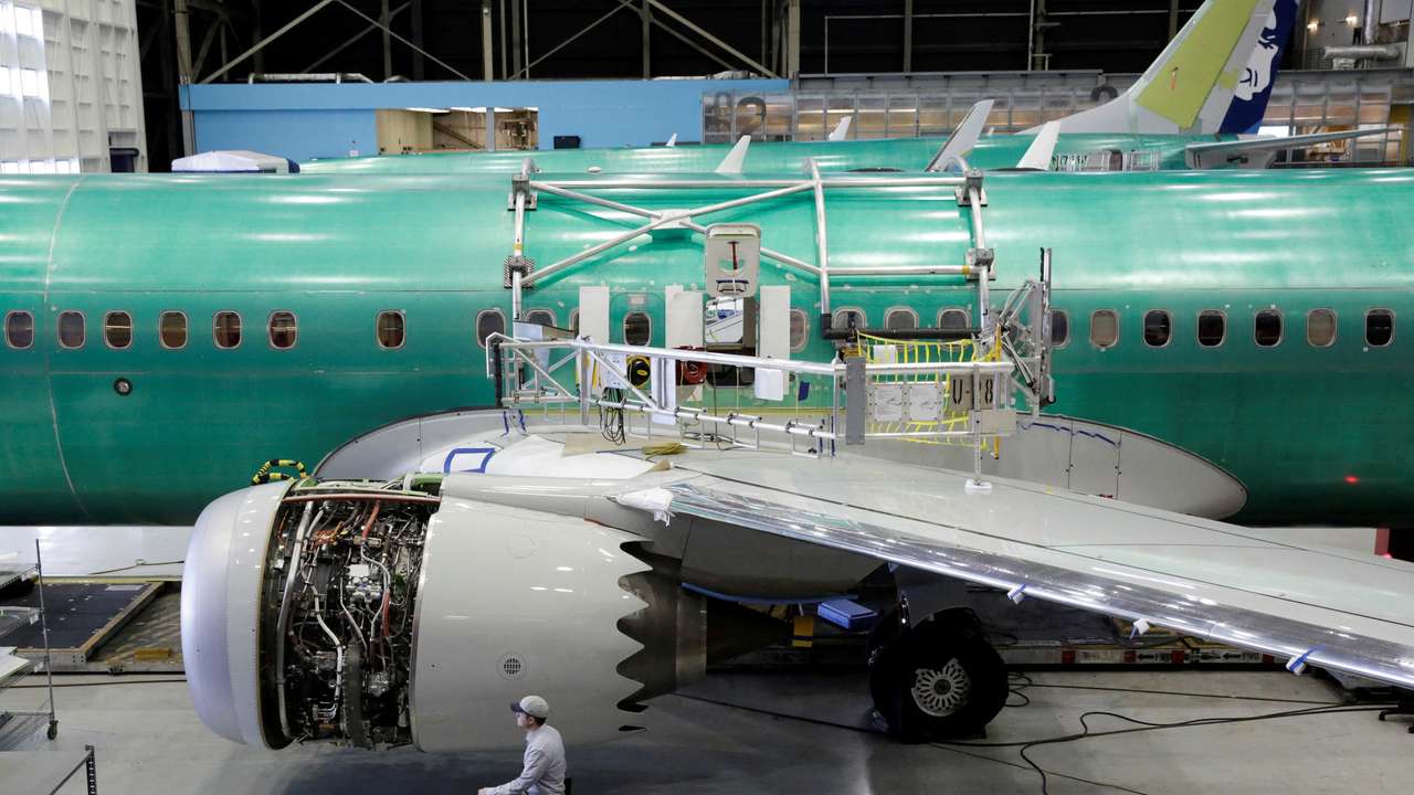 FILE PHOTO: A worker walks past Boeing's new 737 MAX-9 under construction at their production facility in Renton, Washington