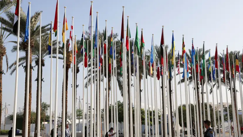 UN security officer walks near the flags at Dubai's Expo City during the United Nations Climate Change Conference (COP28) in Dubai