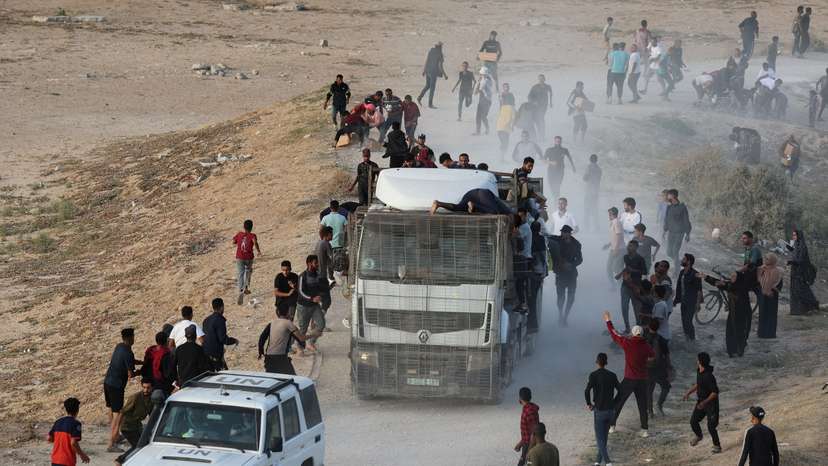 Palestinians climb on a truck to grab aid that was delivered into Gaza through a U.S.-built pier, as seen from central Gaza Strip