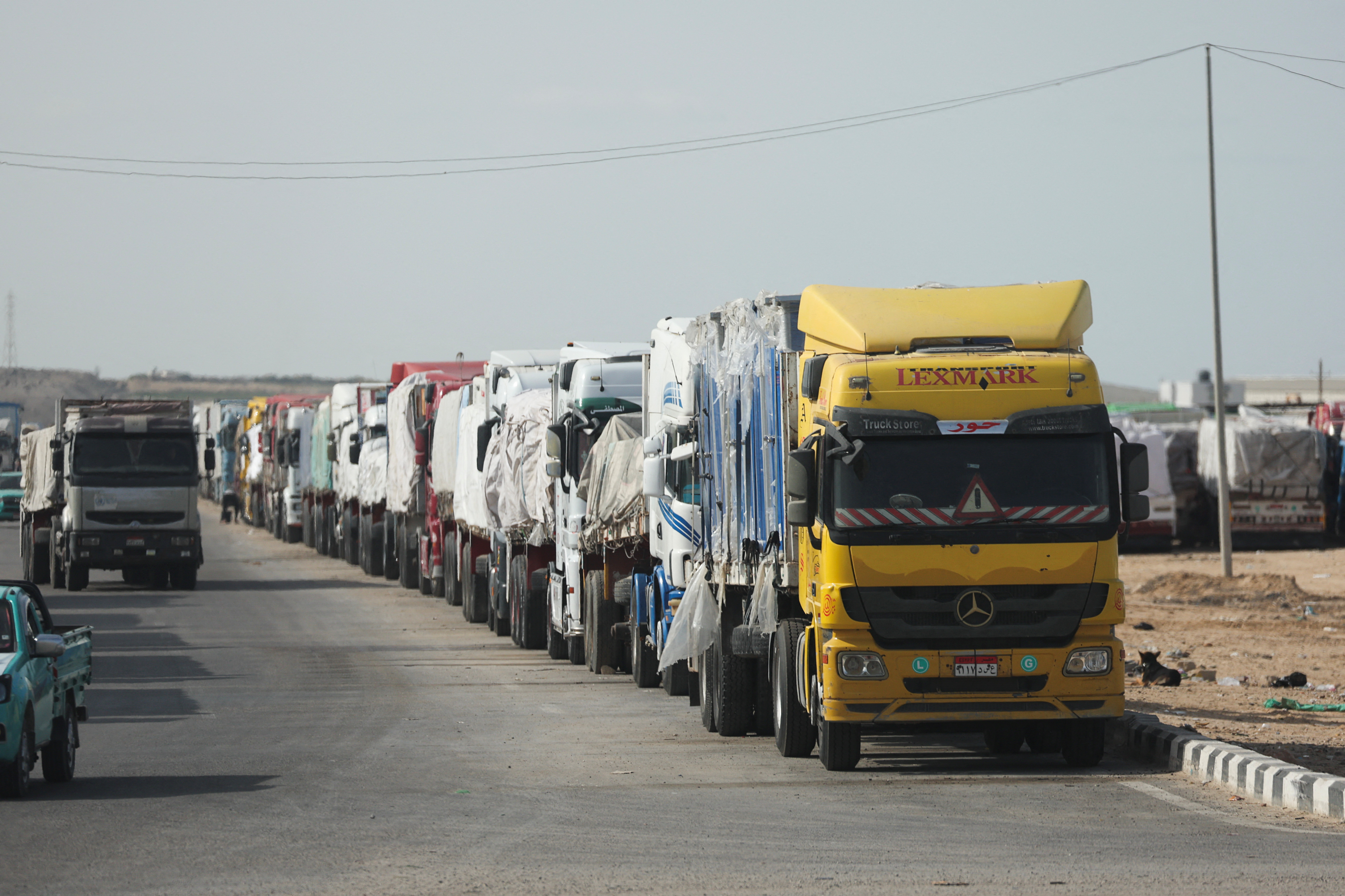 Aid trucks wait near the Rafah border crossing between Egypt and the Gaza Strip