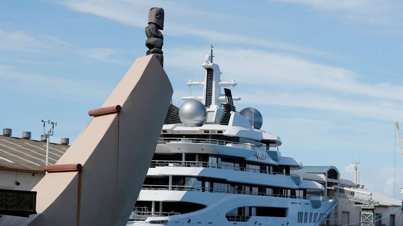 Part of a Hawaii themed cruise ship is seen near the Russian-owned super yacht Amadea which was seized in Fiji by American law enforcement, while it is docked in Honolulu