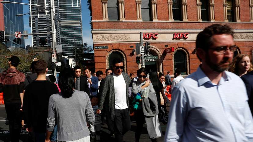 People cross a street in Sydney