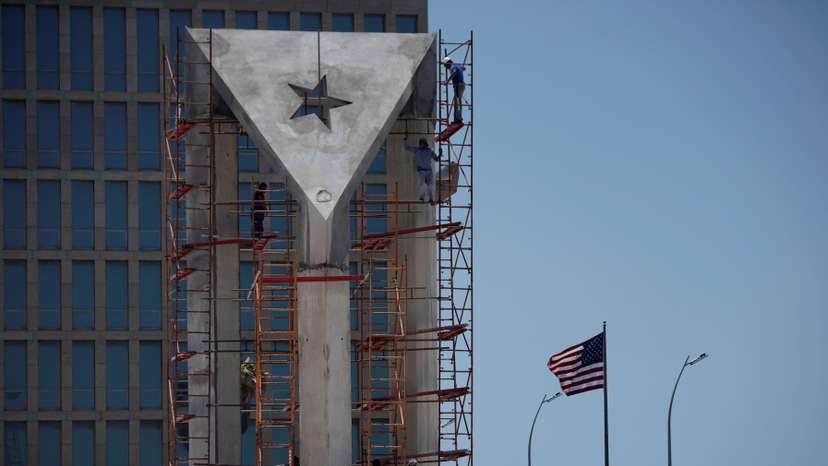Men work in a monument in front of the U.S. Embassy in Havana