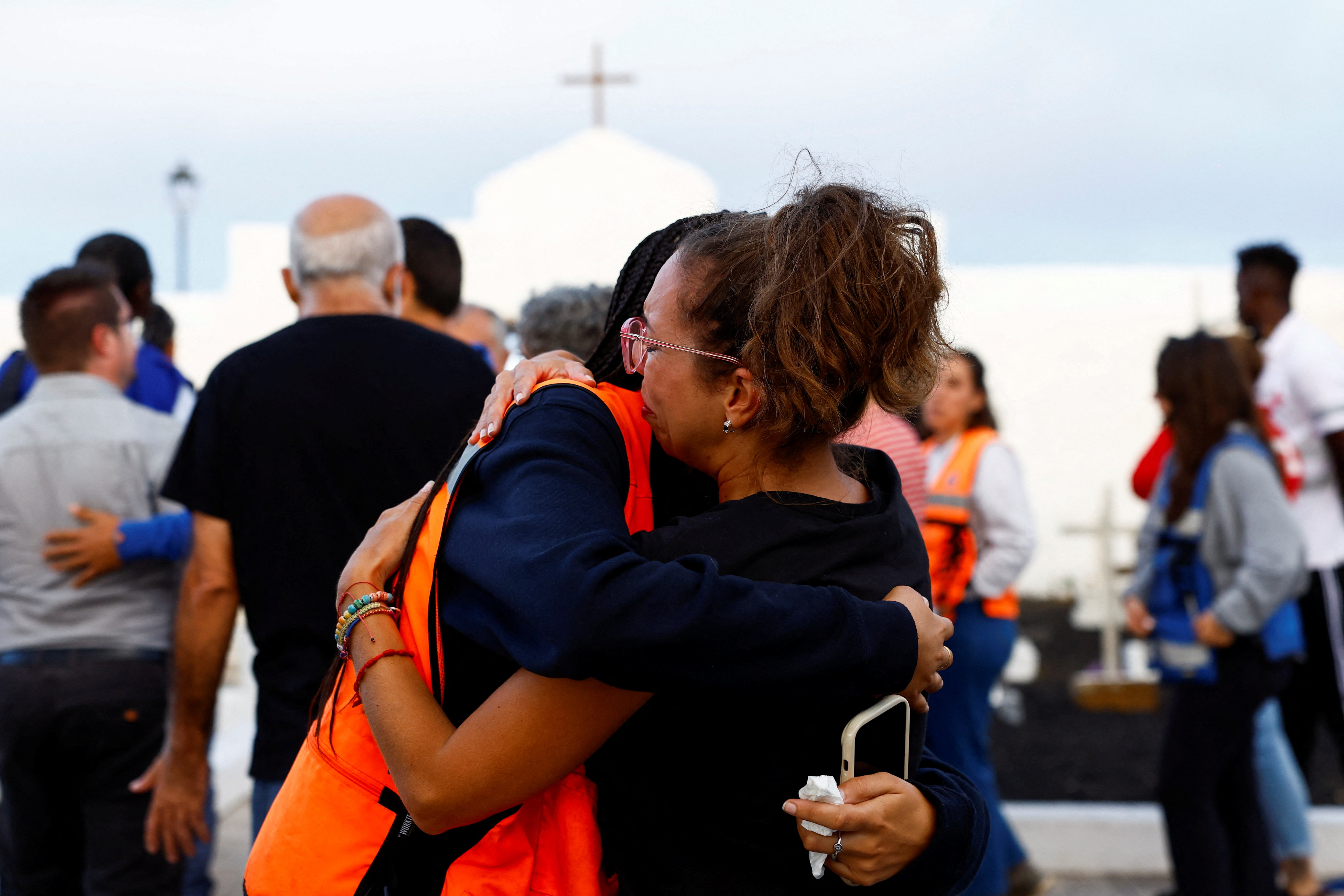 Haridian Marichal is comforted by an NGO volunteer after the burial of a migrant at the Valverde cemetery on the island of El Hierro