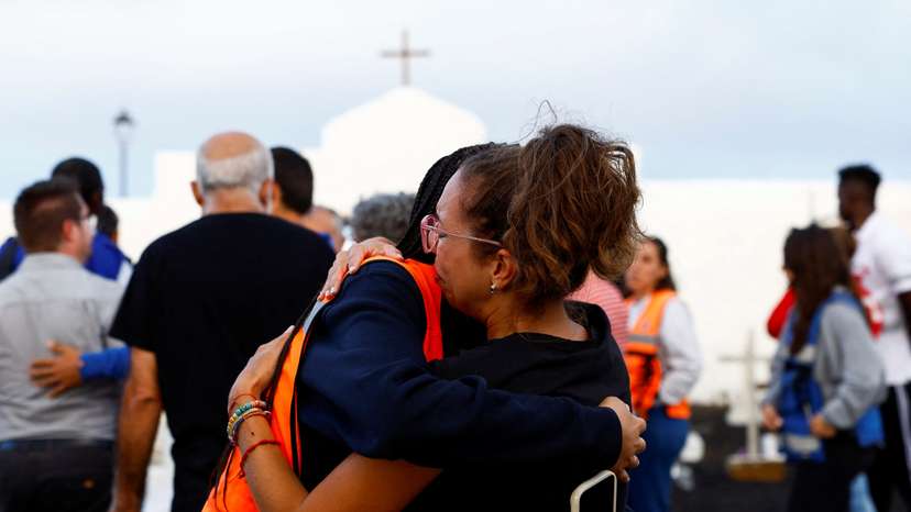 Haridian Marichal is comforted by an NGO volunteer after the burial of a migrant at the Valverde cemetery on the island of El Hierro