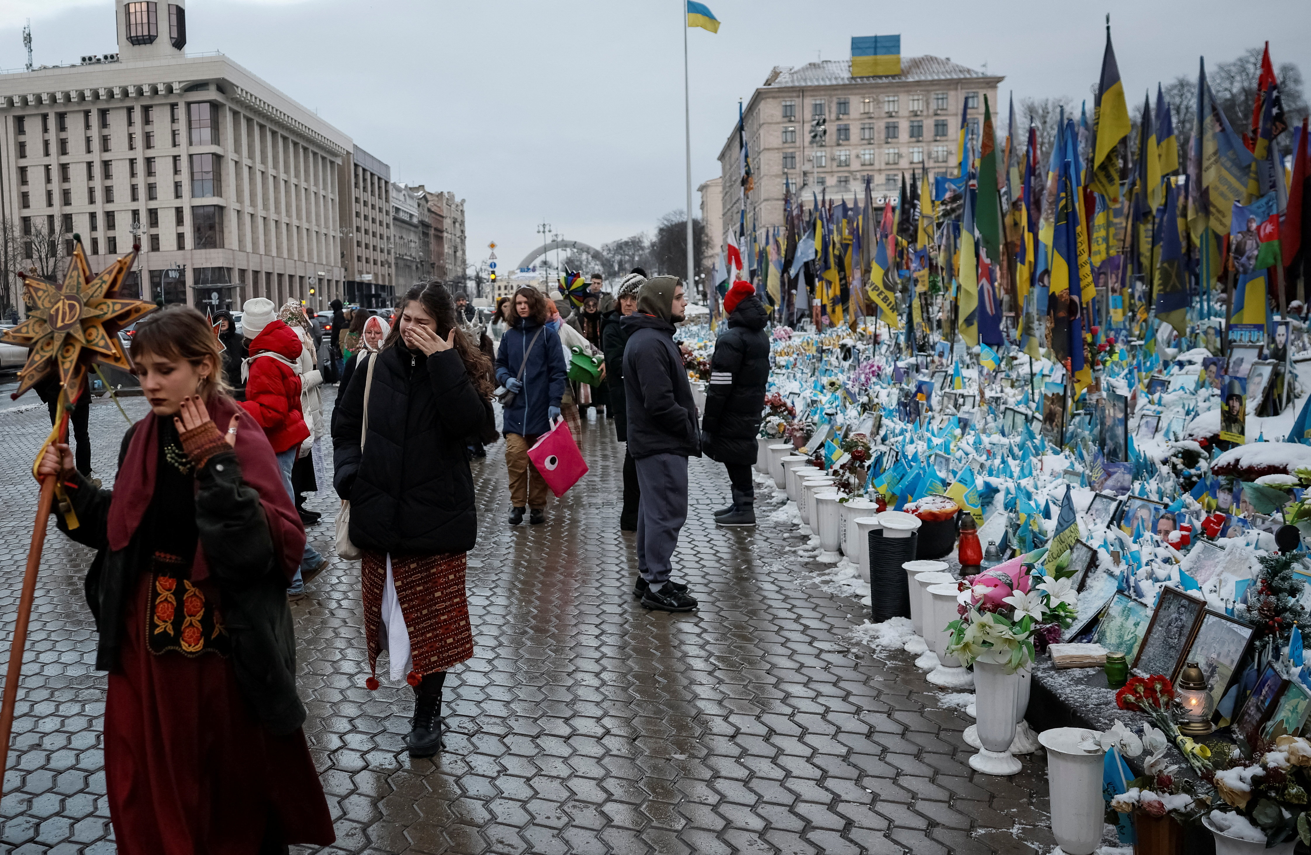 People visit a makeshift memorial in central Kyiv