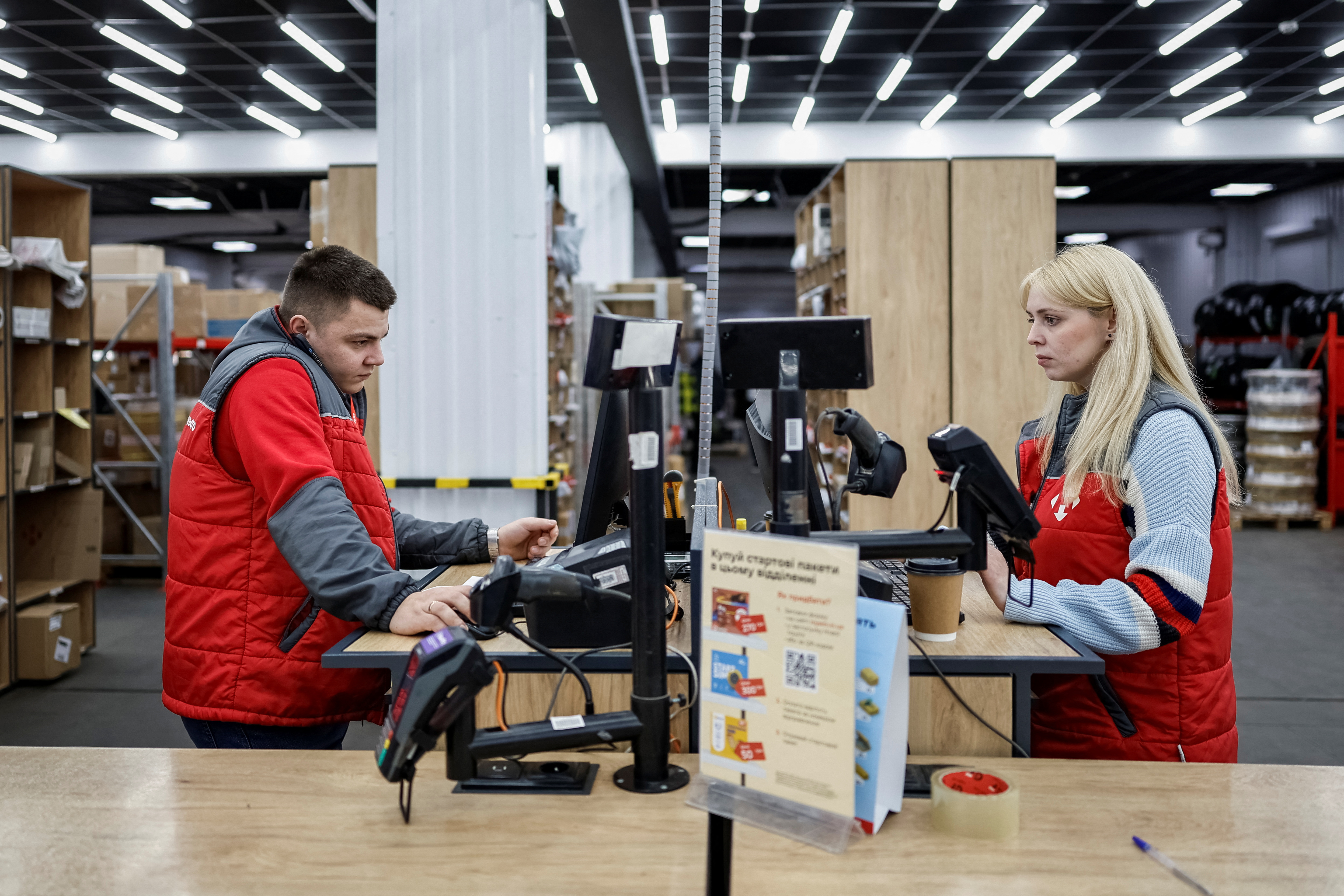 Nova Post employee serves customers at a post office in Chernihiv