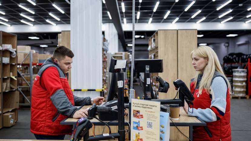 Nova Post employee serves customers at a post office in Chernihiv