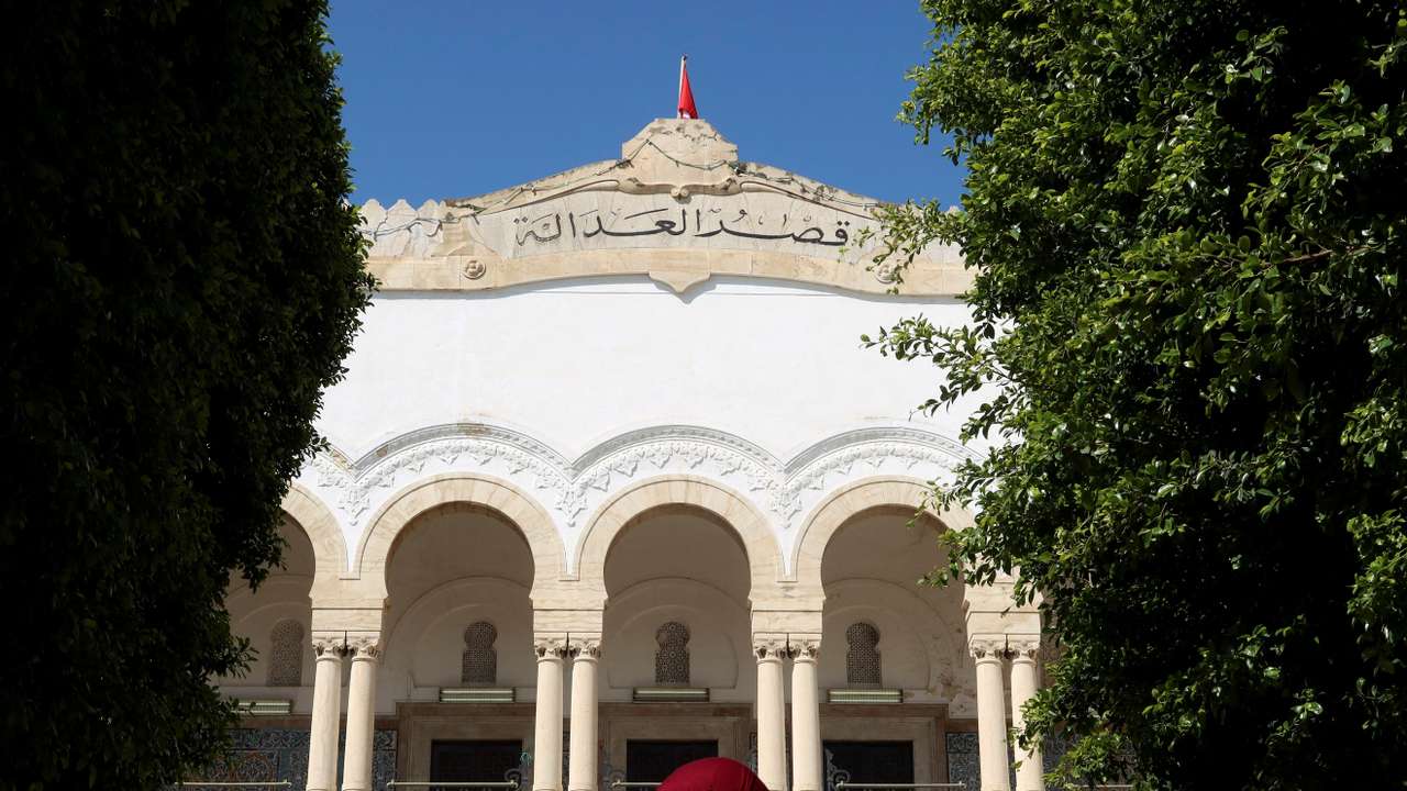FILE PHOTO: A woman walks near the Palace of Justice in Tunis