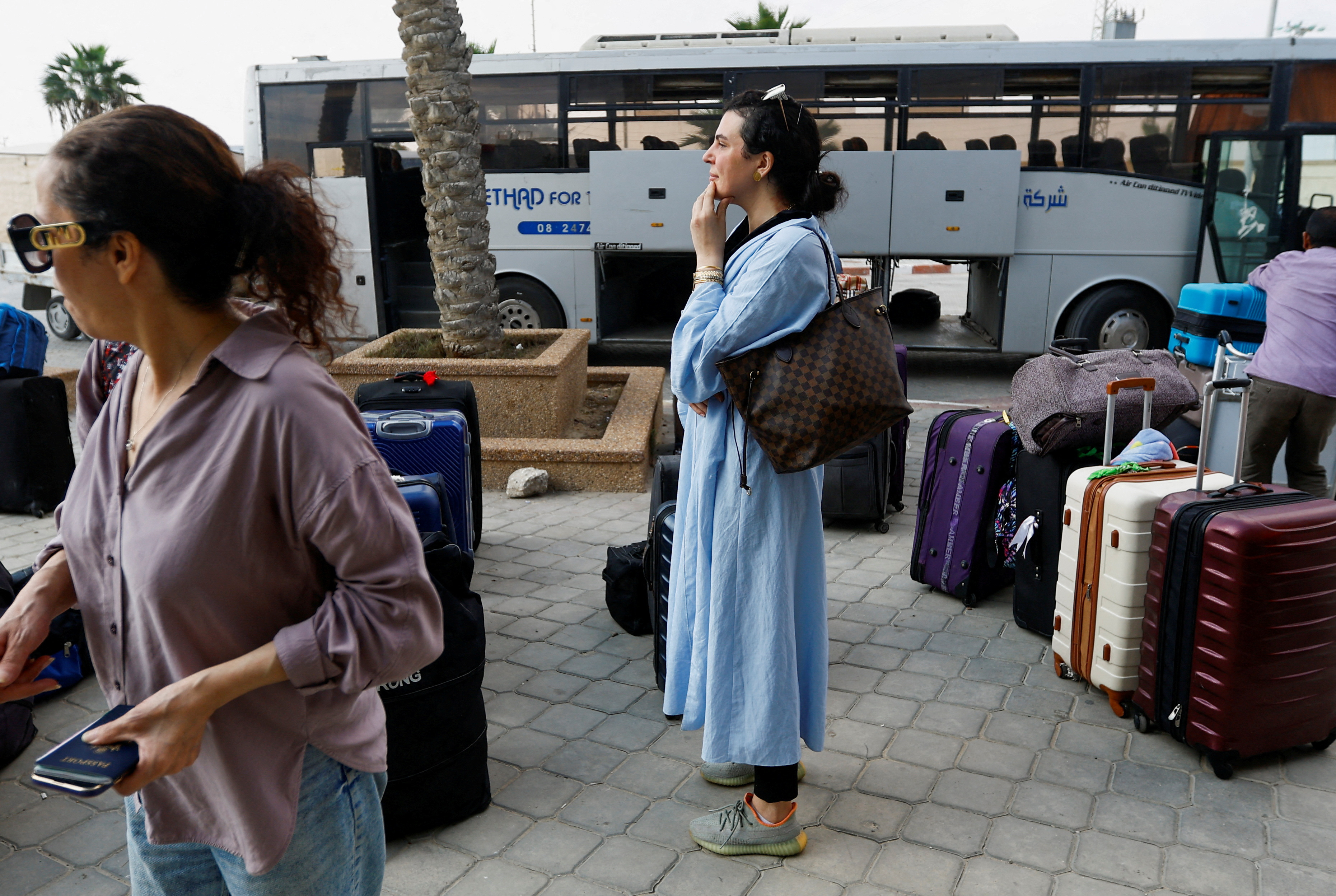 FILE PHOTO: Palestinians holding their foreign passports wait for permission to leave Gaza, at the Rafah border crossing with Egypt