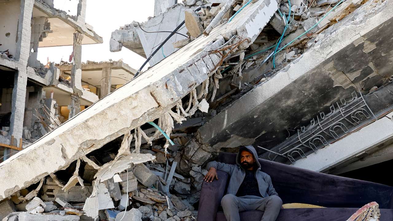 FILE PHOTO: A Palestinian man sits amidst the rubble of buildings destroyed during the Israeli offensive, amid a ceasefire between Israel and Hamas, in Rafah