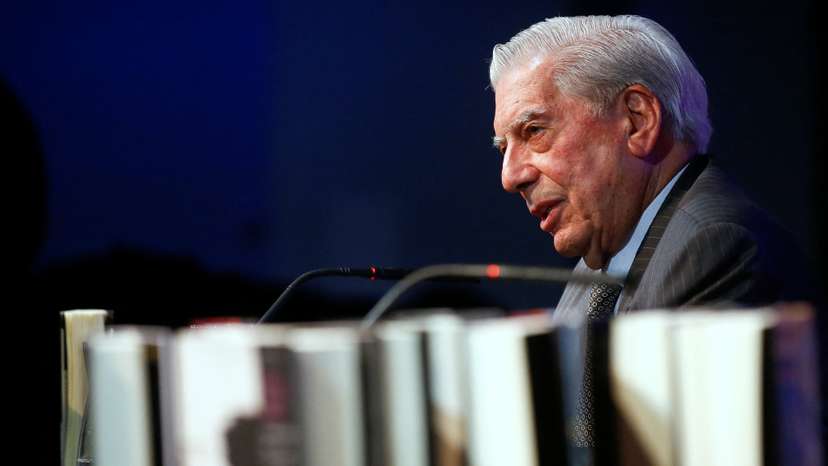 FILE PHOTO: Mario Vargas Llosa, Peruvian writer and recipient of the 2010 Nobel Prize in Literature, sits behind his books during the presentation of his latest novel "Five Corners" in Madrid, Spain