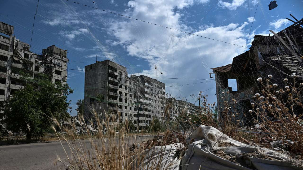 FILE PHOTO: View shows residential building damaged by Russian military strikes and anti-drone nets installed over a street in the frontline town Orikhiv