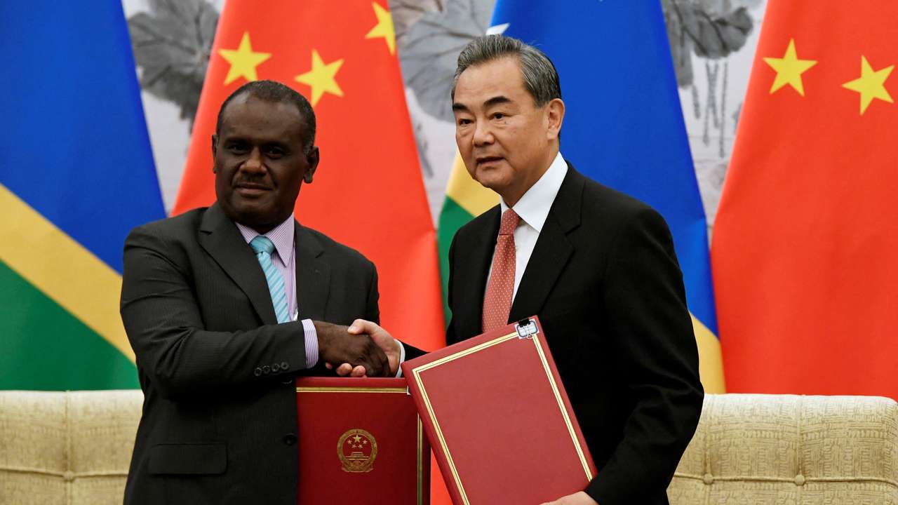 FILE PHOTO: Chinese State Councilor and Foreign Minister Wang Yi shakes hands with Solomon Islands Foreign Minister Jeremiah Manele during a ceremony in Beijing