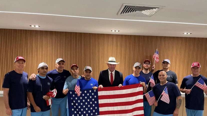 U.S. citizens released from Venezuela pose for a photo holding U.S. flags after a prisoner swap