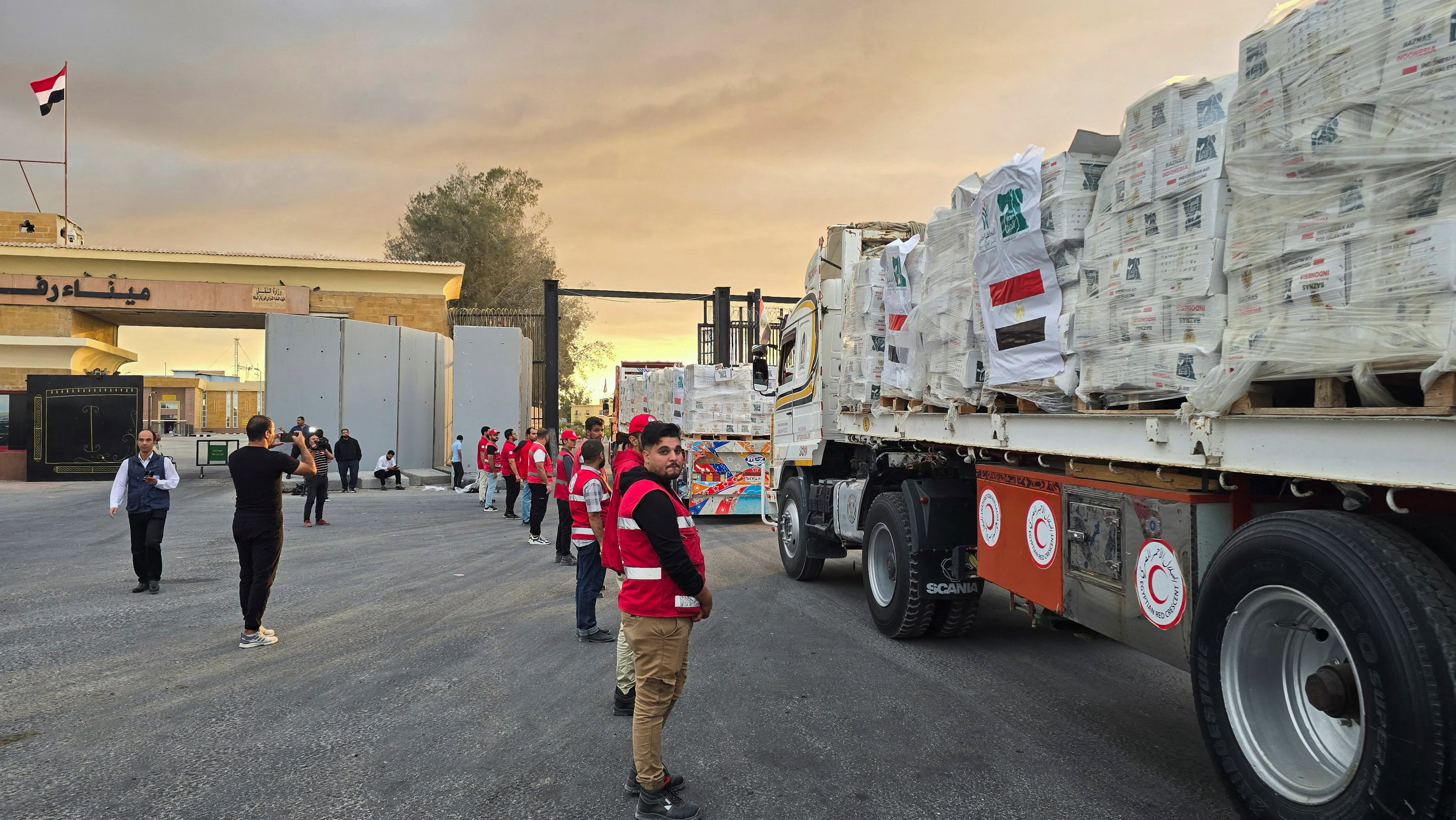 Trucks carrying aid bound for Gaza cross the border crossing between Egypt and the Gaza Strip