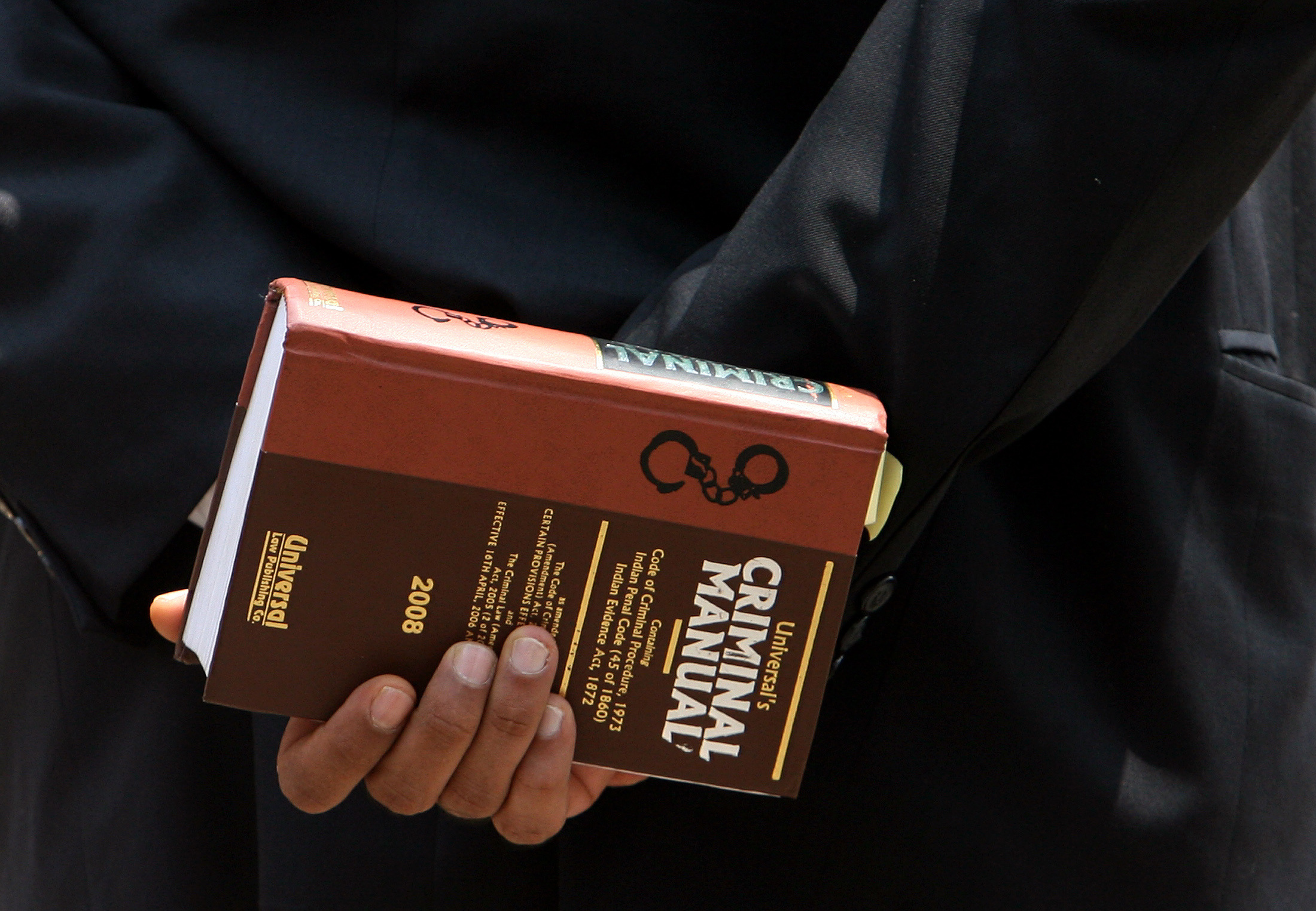 Lawyer holds a book as he waits to enter the Arthur Road jail in Mumbai