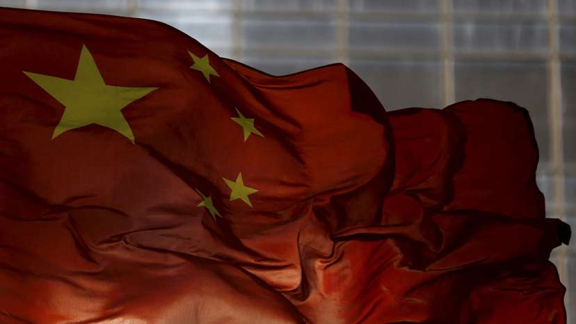 FILE PHOTO: China's national flag flutters at a business district in Beijing