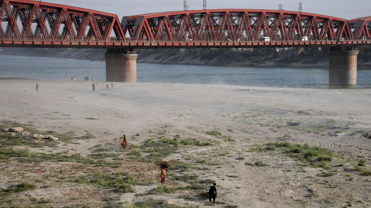 FILE PHOTO: People walk on the dry riverbed of the Indus River in Hyderabad, Pakistan