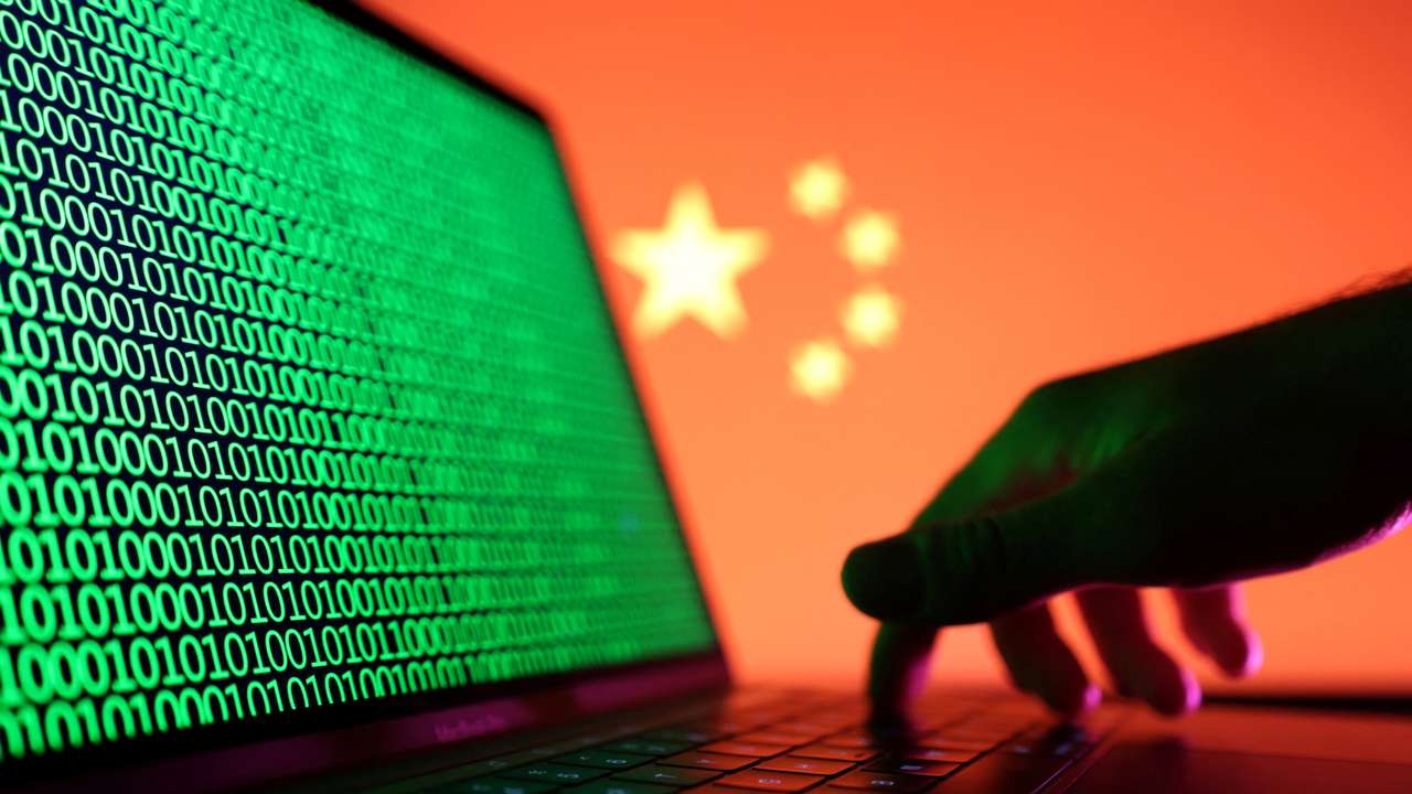 Illustration shows a laptop with binary codes displayed in front of the Chinese flag